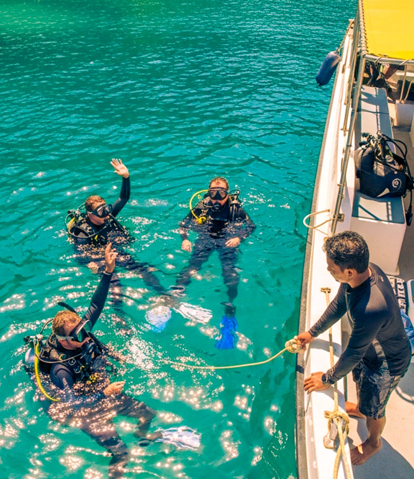 Taucher auf einem Tagesausflug vor einem Tauchboot auf Bali.